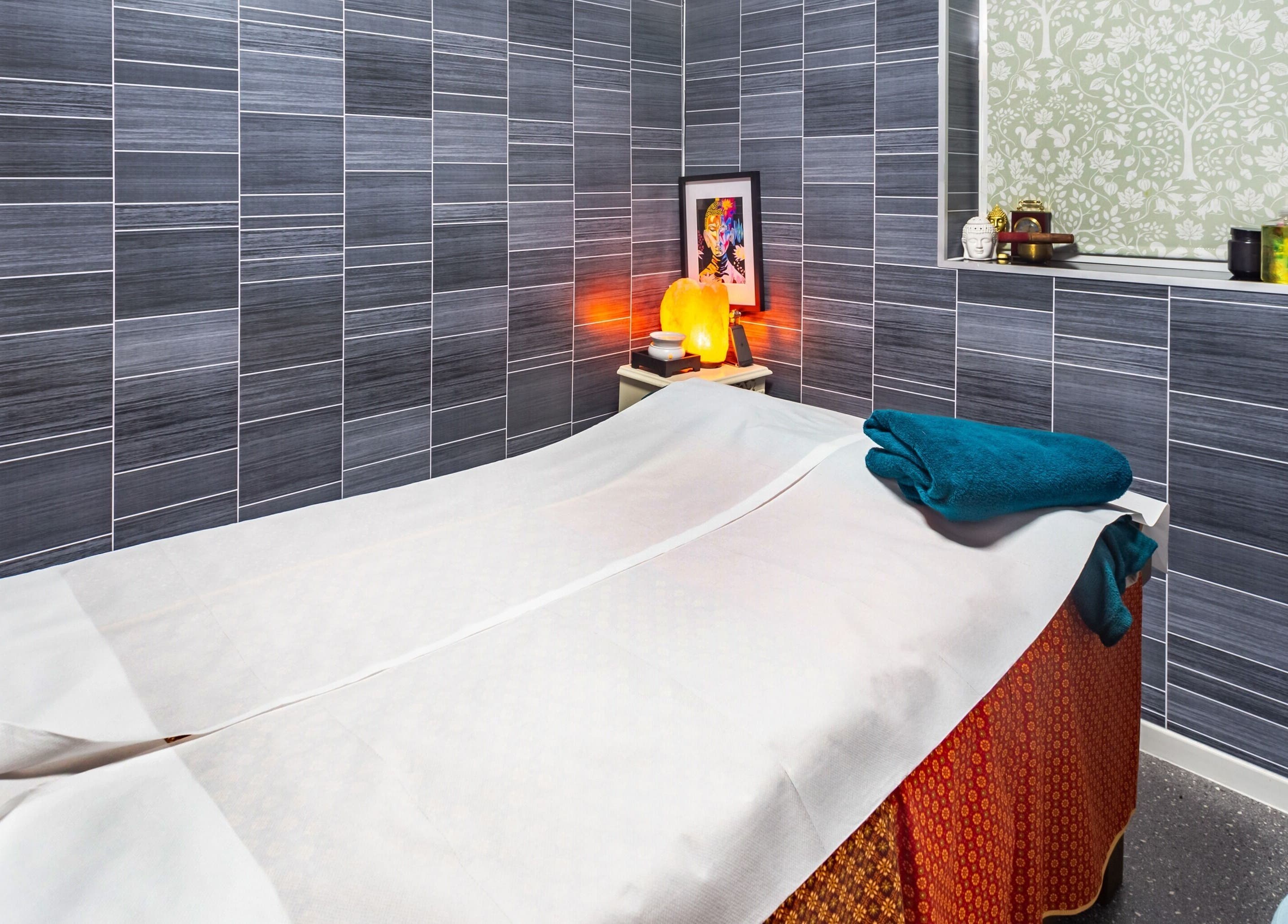 Cozy massage room at Thai Spa & Clinic, March, England, with warm lighting and modern decor.