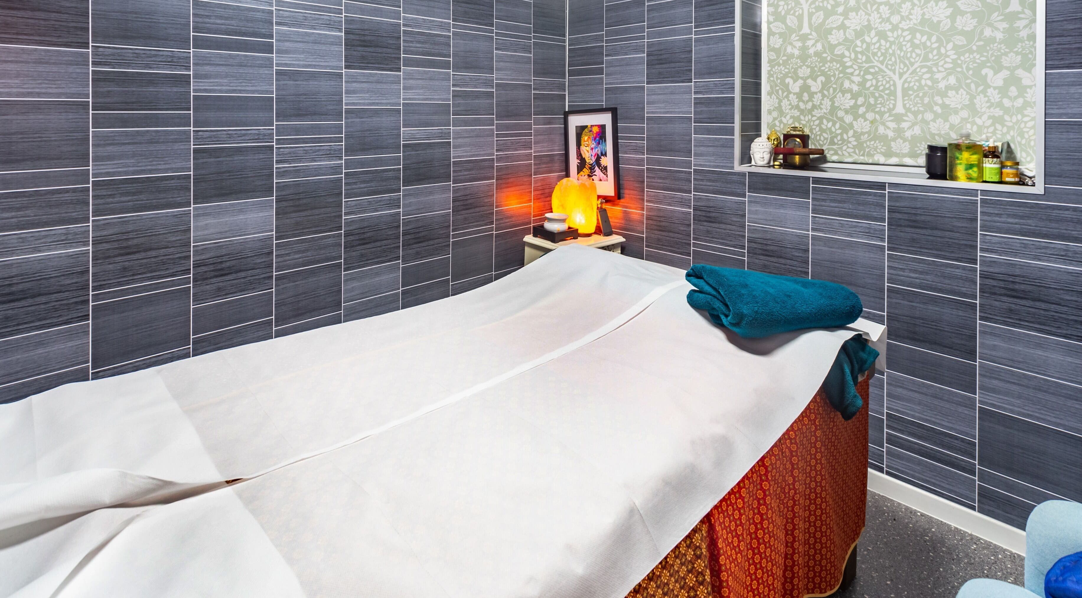 Cozy massage room at Thai Spa & Clinic, March, England, with warm lighting and modern decor.
