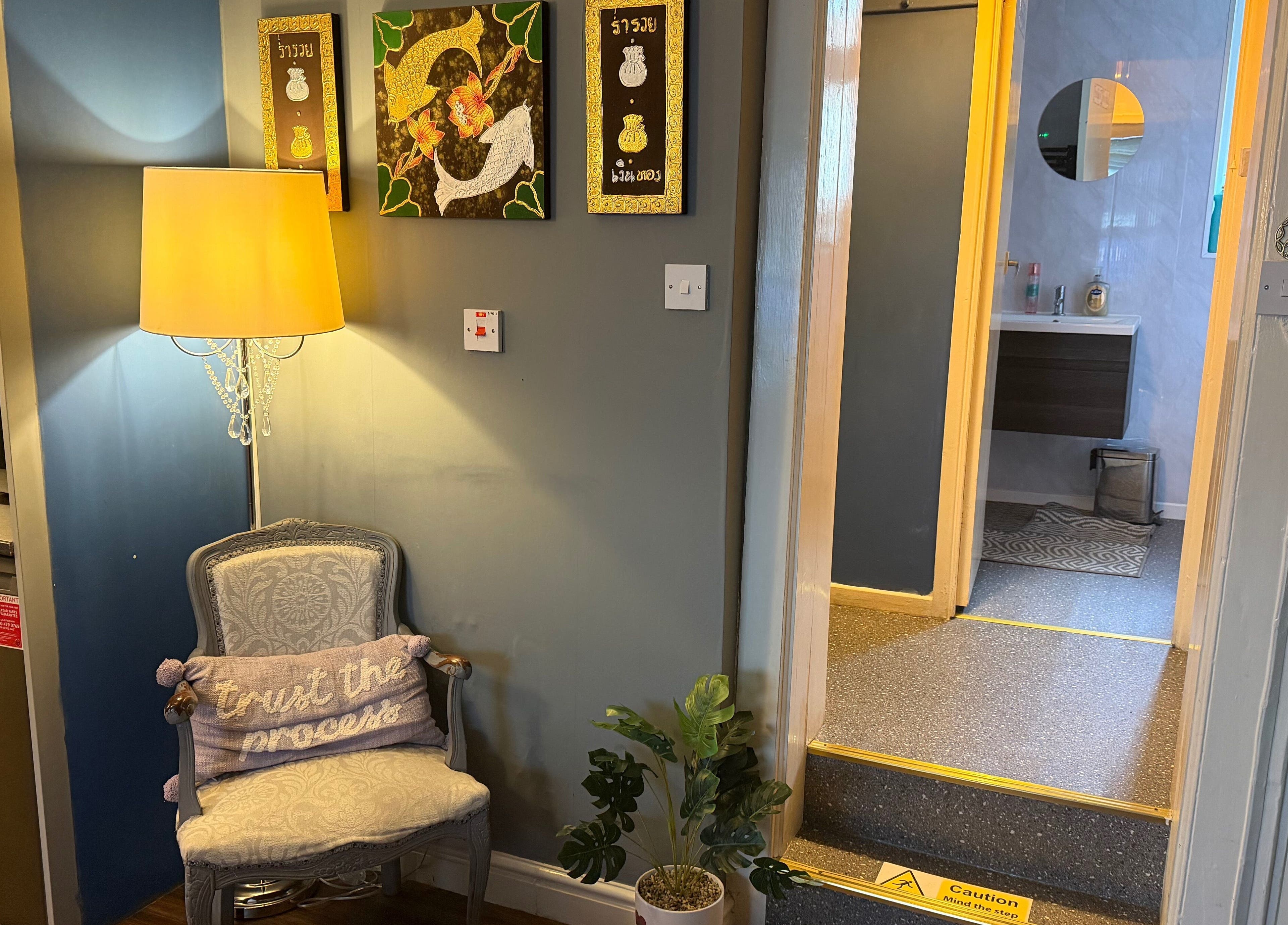 Welcoming corner at Thai Spa & Clinic, March, England featuring a cozy chair, lamp, and decor.