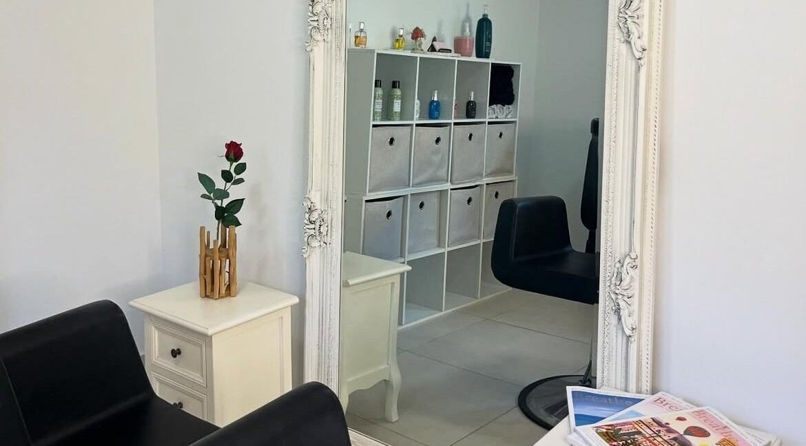 Chic salon decor at Tee's Hair Lounge, Concord, New South Wales, AU featuring a stylish black chair and framed mirror.