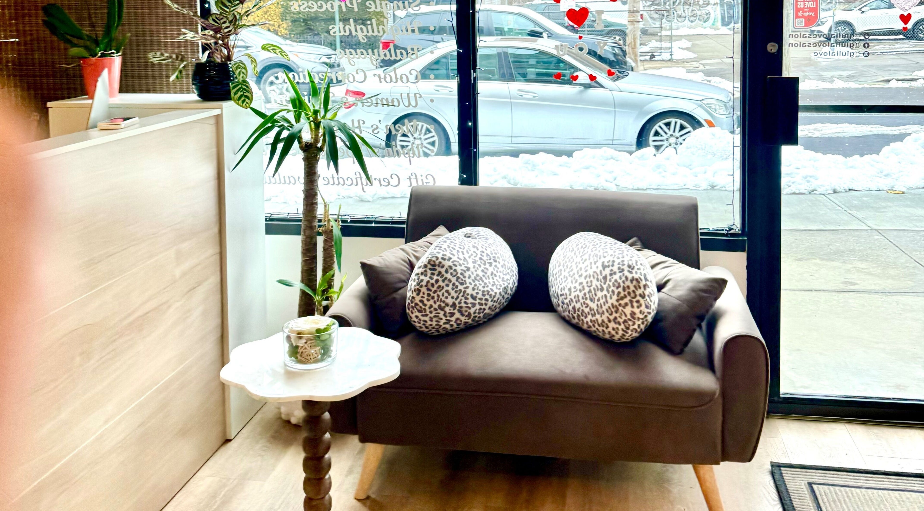 Inviting seating area at Giulia Love Salon in New York, New York, US with plush sofa and decorative plants.