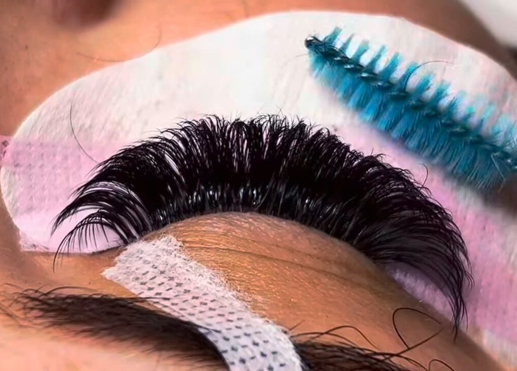 Detailed lash grooming at EyeLuxeLounge in Tuffley, England, showcasing professional eyelash extension care.