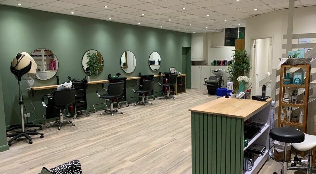 Stylish interior of Shearclass Hair and Beauty, Sherston, England, with modern salon setup and green accents.