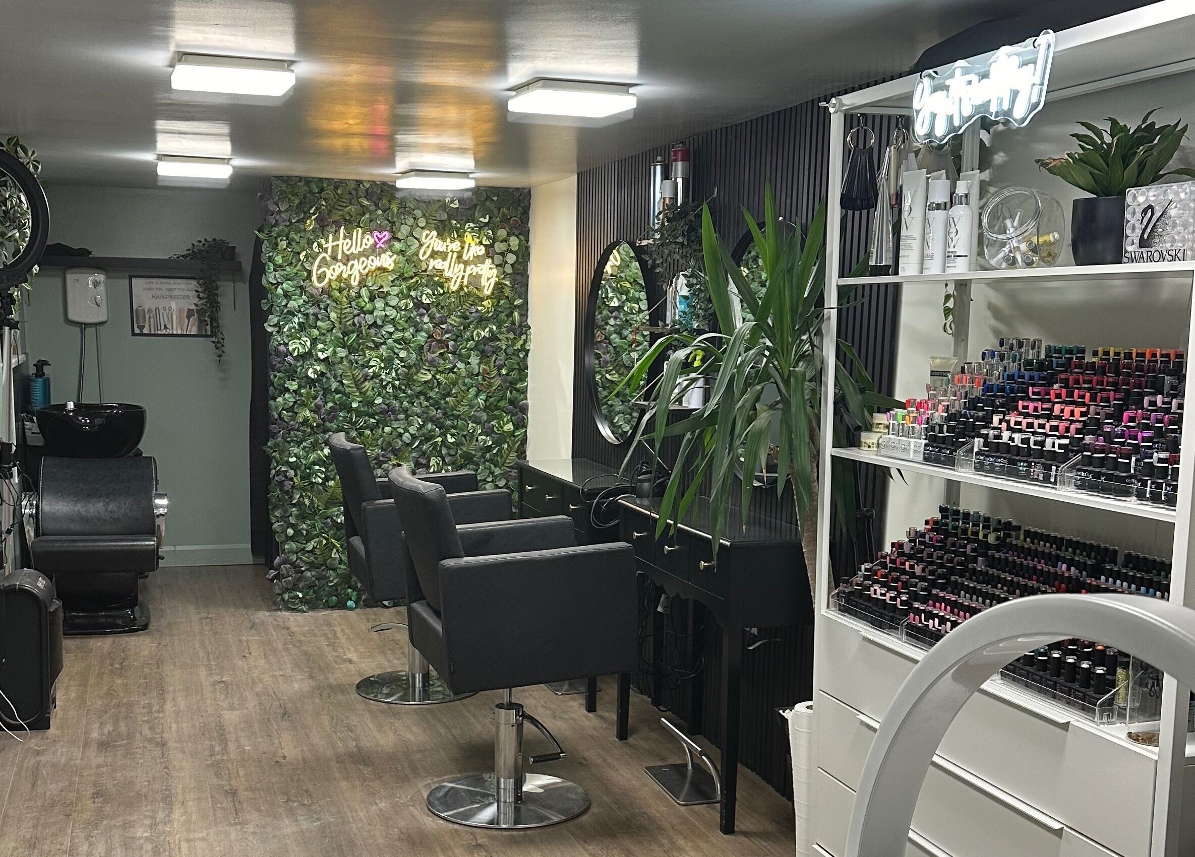 Stylish interior of Envious Salon in Crawley, England, GB, showcasing elegant chairs and vibrant greenery.