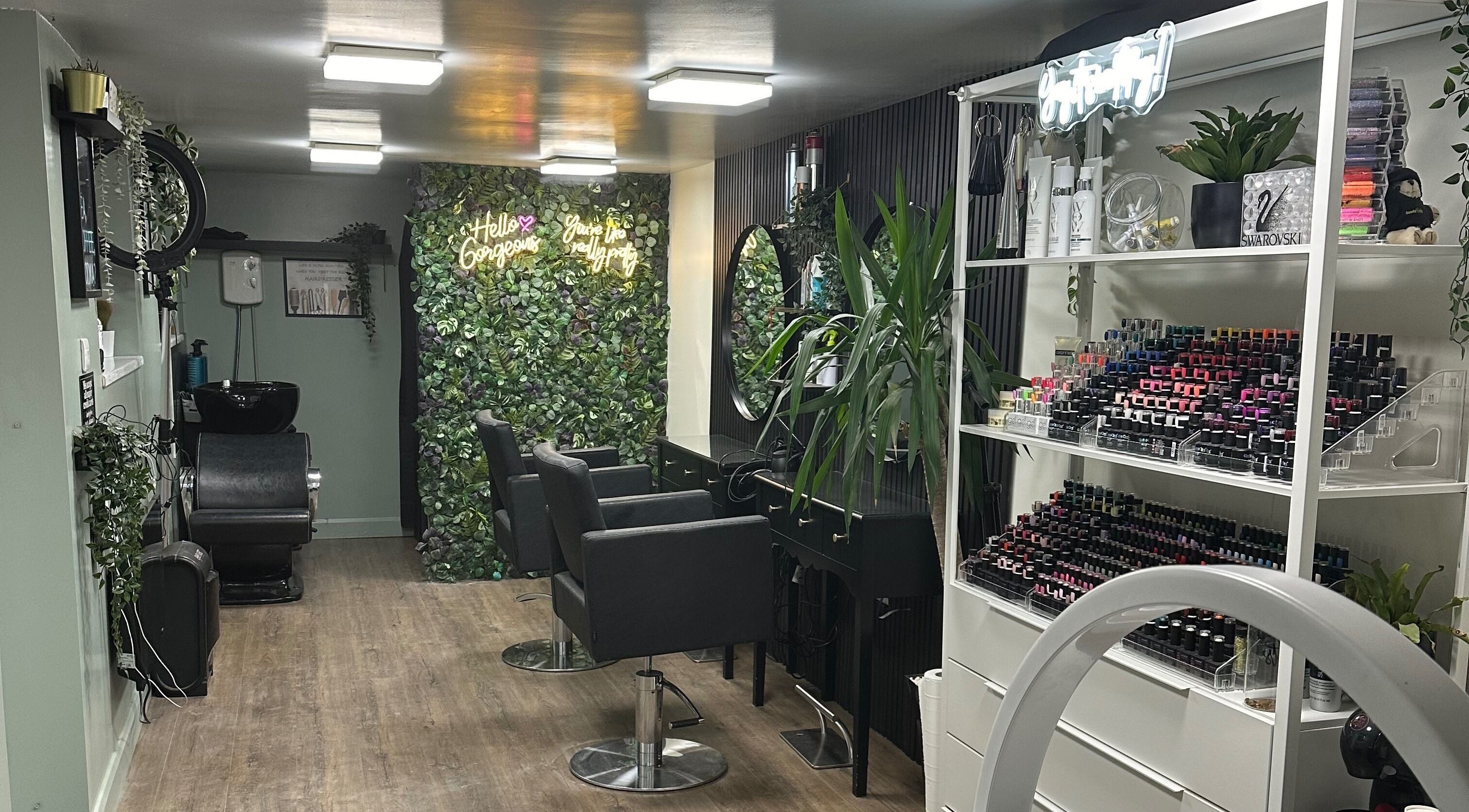 Stylish interior of Envious Salon in Crawley, England, GB, showcasing elegant chairs and vibrant greenery.