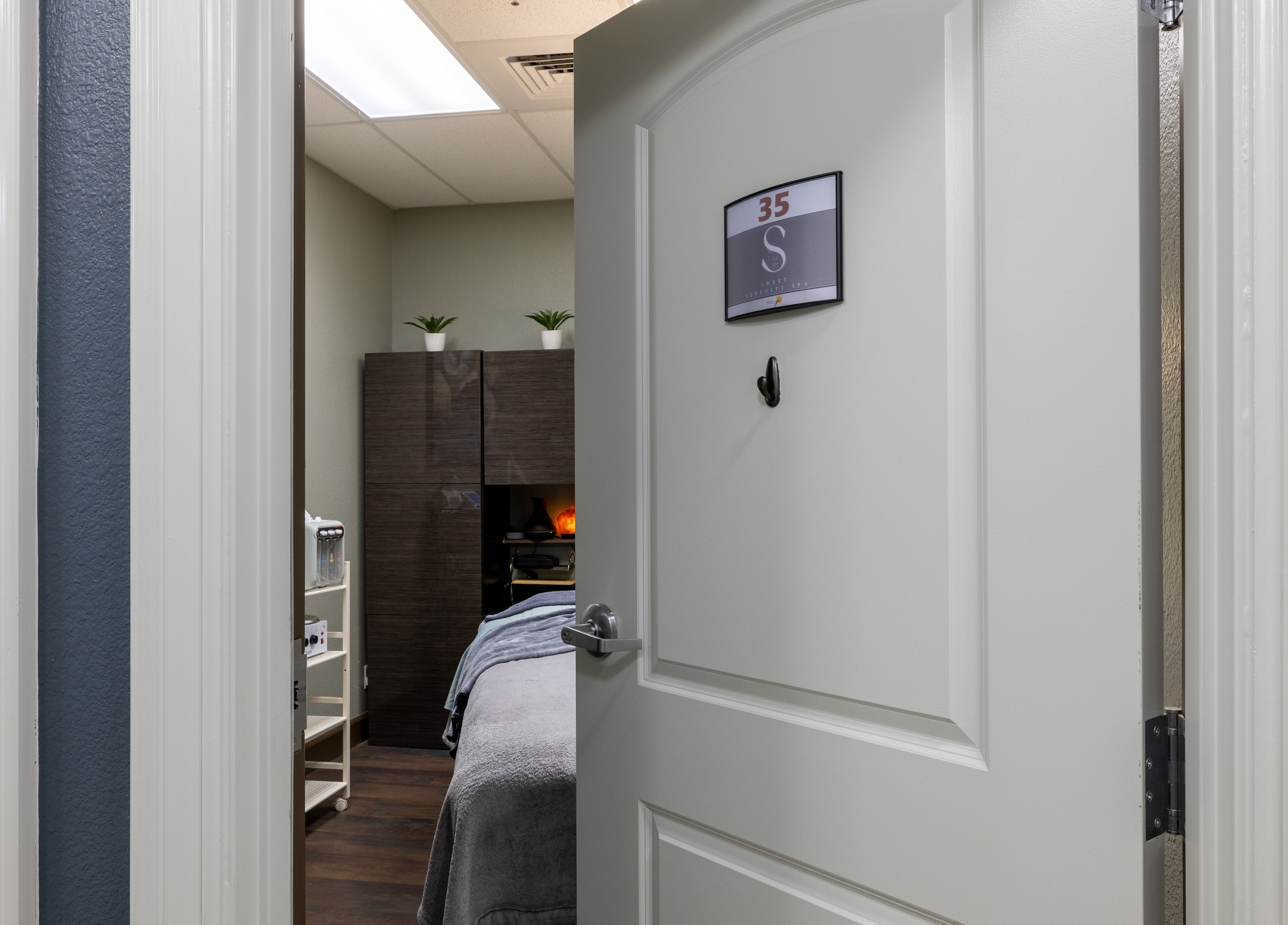 Open spa door at Sweet Serenity Spa in Charlotte, North Carolina, US, revealing a peaceful treatment room.