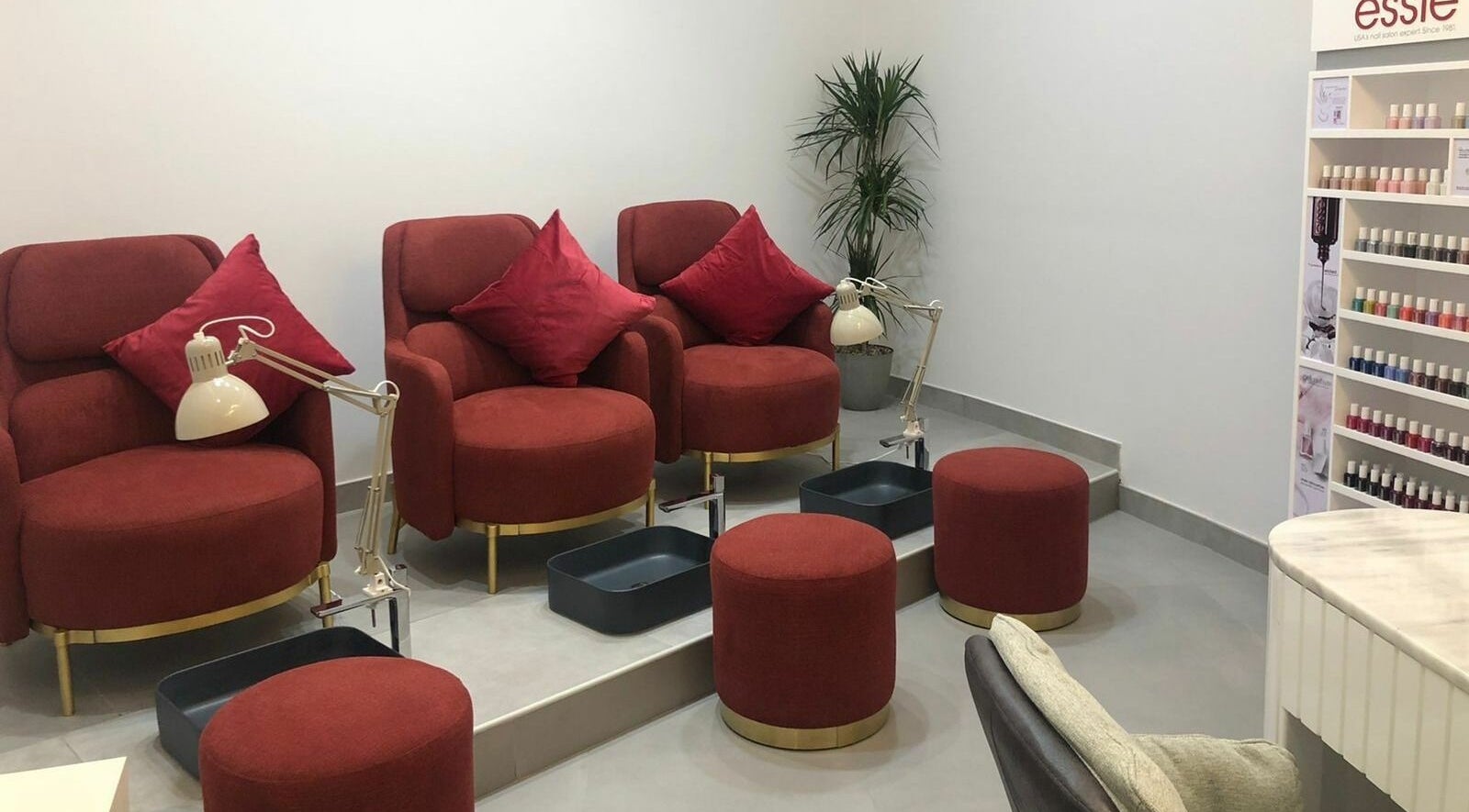 Cozy pedicure area with red seats at Ok Beauty Salon, دبي, دبي, AE, offering a stylish and relaxing environment.