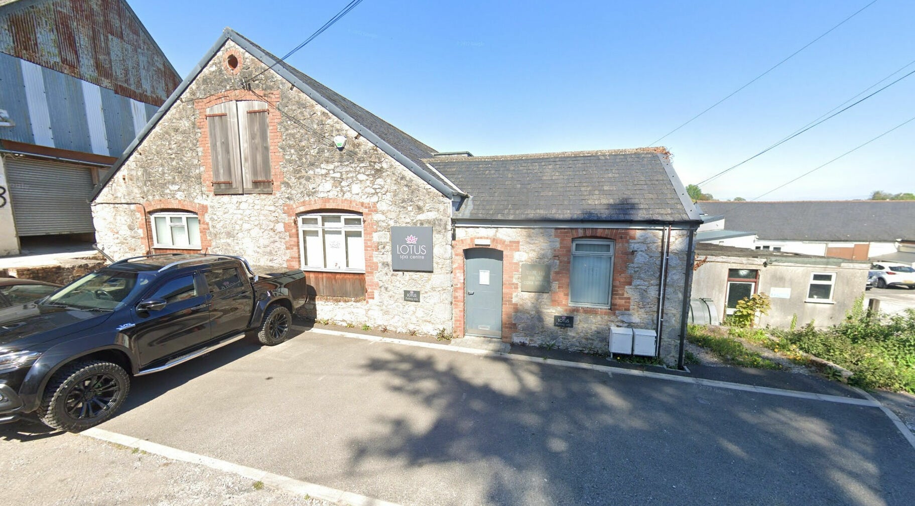 Exterior view of Lotus Spa and Academy Centre in Abbotskerswell, England, showcasing rustic stone design.