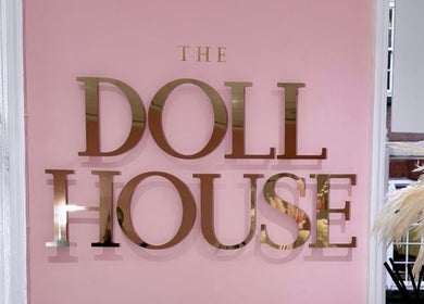 Elegant gold 'The Doll House York' sign on pink wall at York, England, GB location.