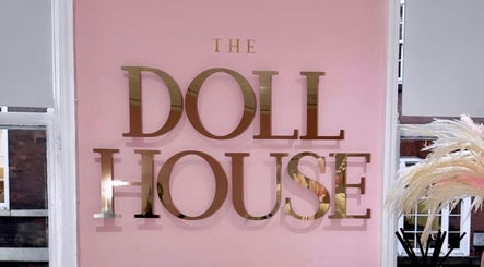Elegant gold 'The Doll House York' sign on pink wall at York, England, GB location.
