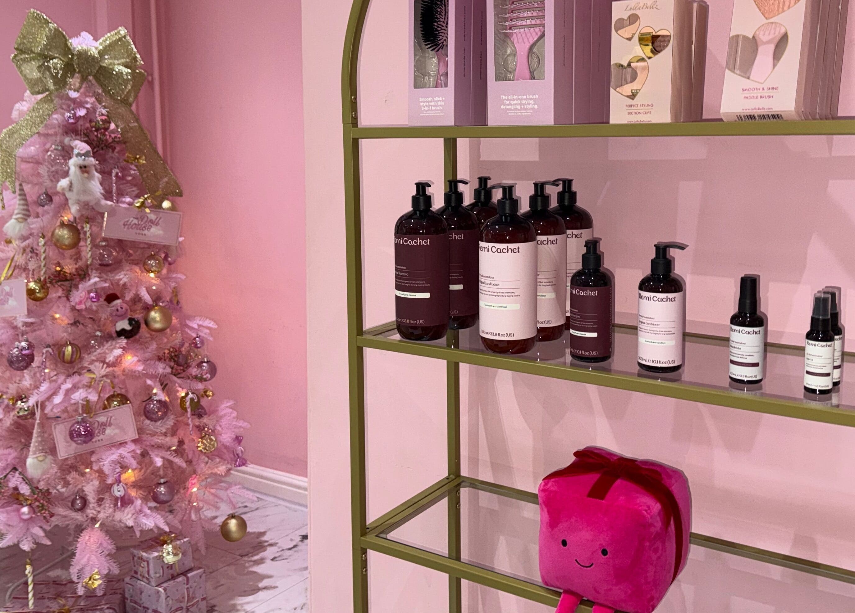 Festive pink-lit spa display at The Doll House York, York, England, GB showcasing beauty products and decor.