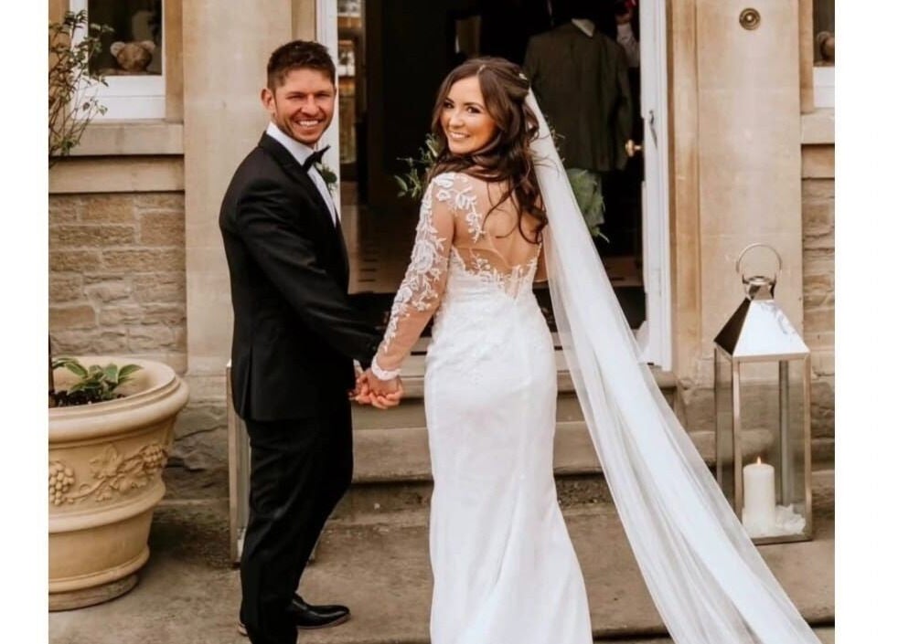 Bride and groom smiling in elegant attire at Jenna Mcdonnell venue, Newport, Wales, GB.