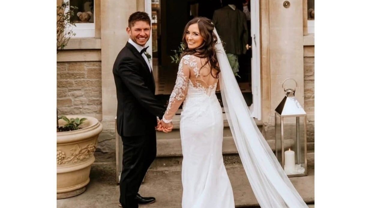 Bride and groom smiling in elegant attire at Jenna Mcdonnell venue, Newport, Wales, GB.