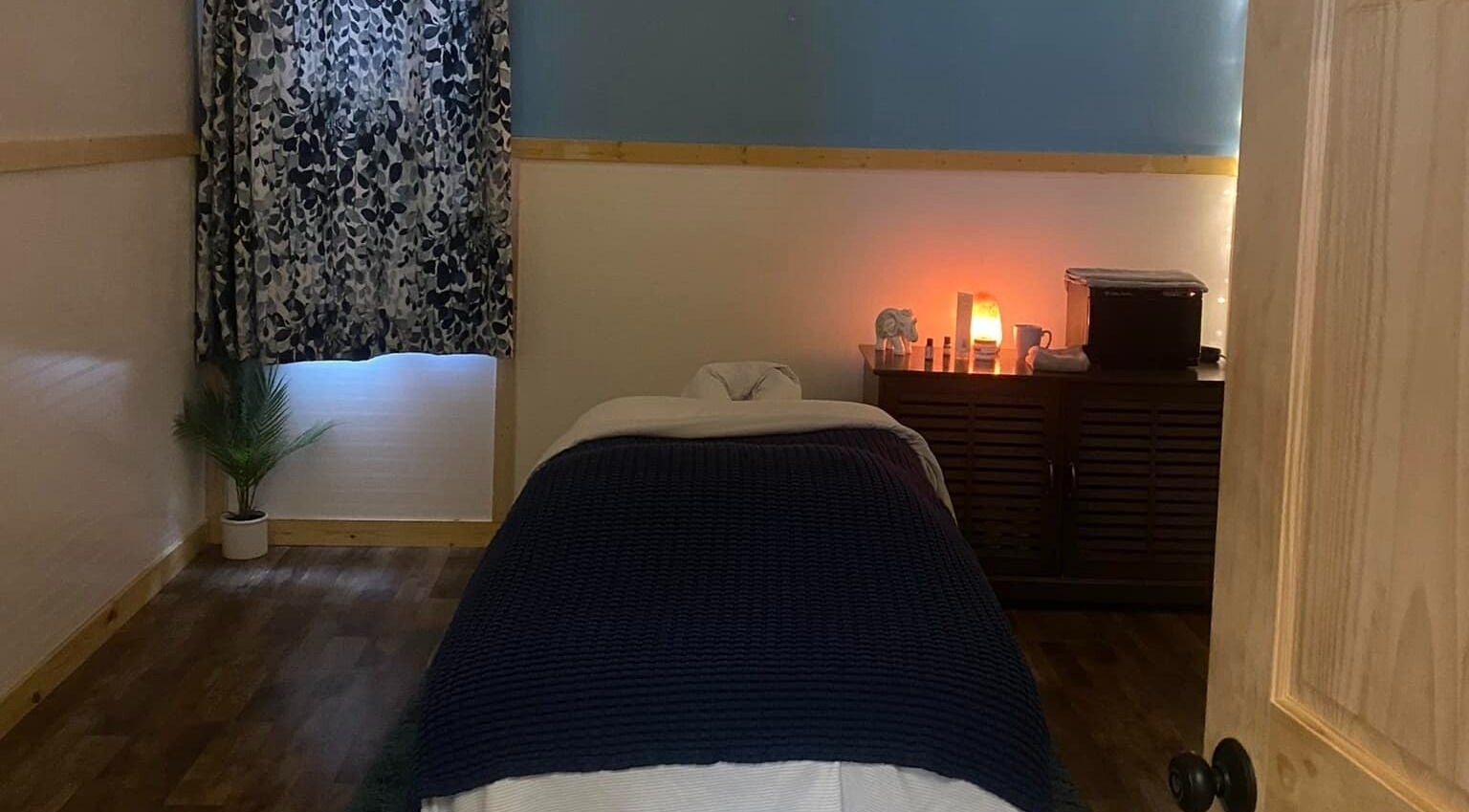 Serene massage room at Sheboygan Wellness Studio in Sheboygan, Wisconsin, US, featuring a cozy bed and warm lighting.