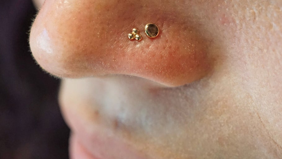 Gold nose studs at Vaughn Body Arts in Monterey, California, US enhance individual style and beauty.