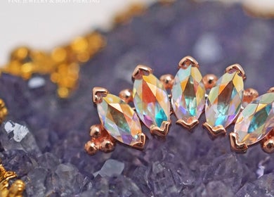 Stunning iridescent jewelry at Vaughn Body Arts, Monterey, California, US, displayed on amethyst crystals.