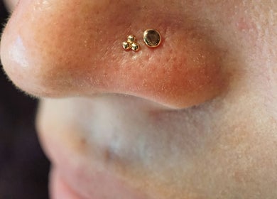 Elegant gold nose piercing at Vaughn Body Arts in Monterey, California, US, showcasing fine craftsmanship.