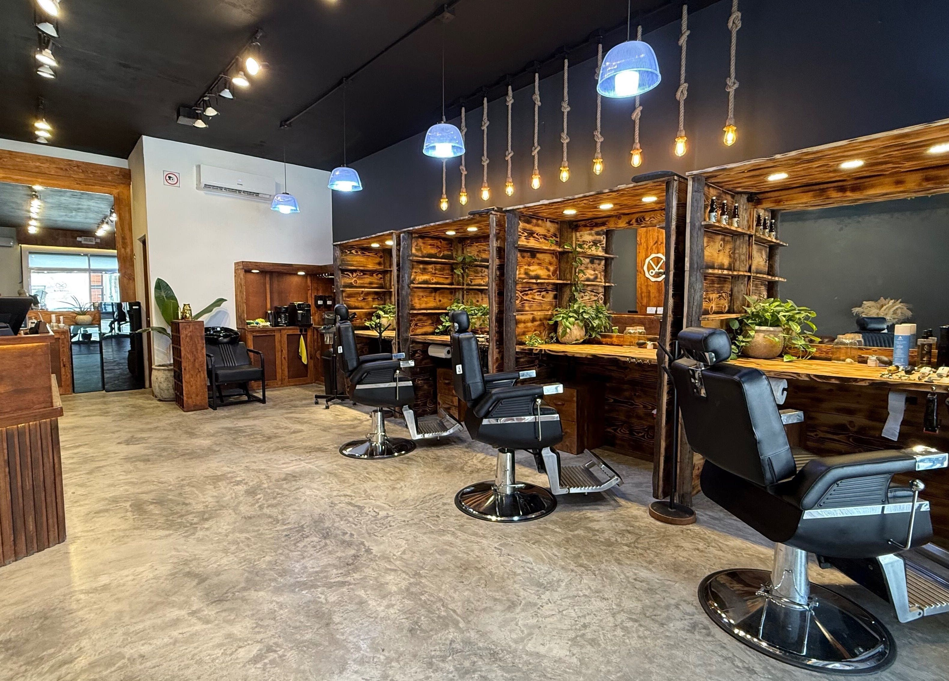 Interior cálido de Barberos Tulum - Calle Andrómeda en Tulum, Quintana Roo, MX, con sillas de barbero modernas.