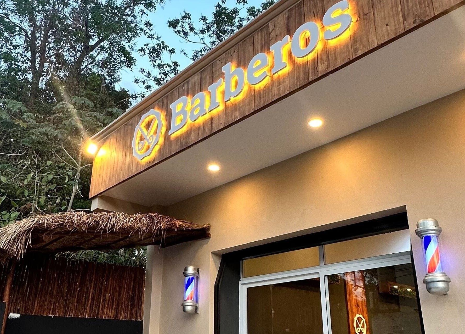 Fachada iluminada de Barberos Tulum - Calle Andrómeda en Tulum, Quintana Roo, MX con letrero distintivo.