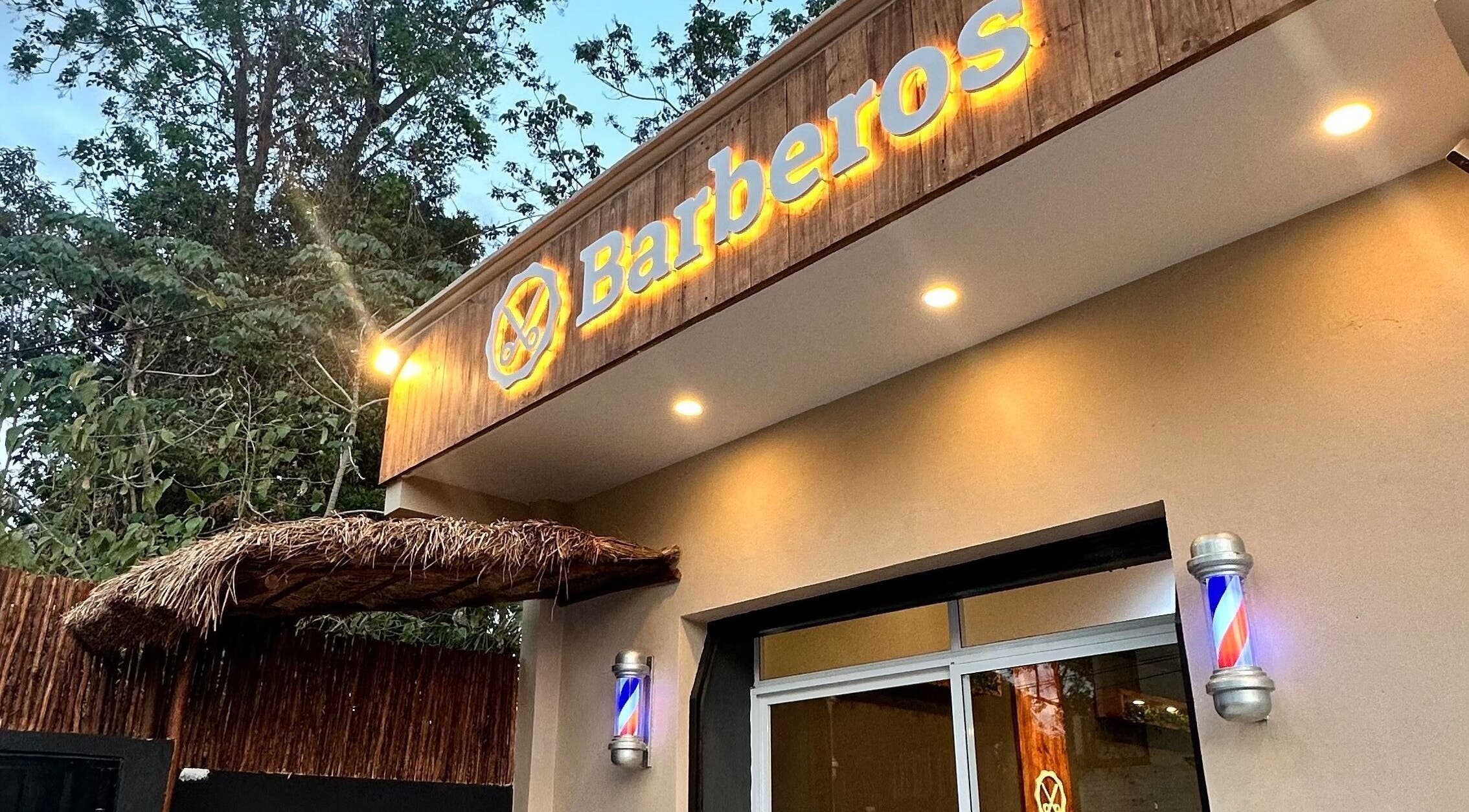 Fachada iluminada de Barberos Tulum - Calle Andrómeda en Tulum, Quintana Roo, MX con letrero distintivo.