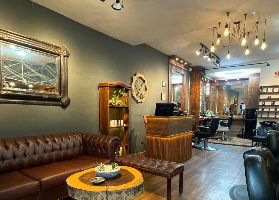 Interior acogedor de Barberos Tulum - Av. Kukulkán, Tulum, Quintana Roo, MX, con sofás de cuero y decoración elegante.