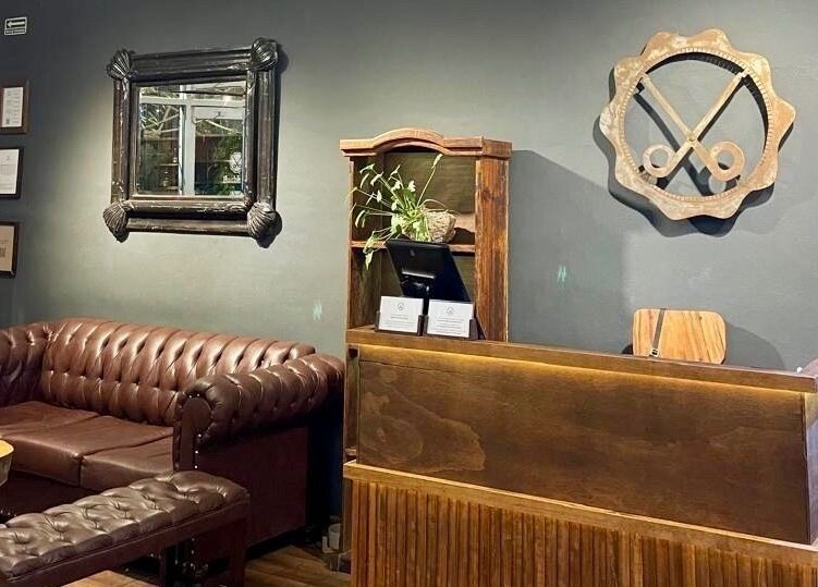 Recepción de Barberos Tulum - Av. Kukulkán en Tulum, Quintana Roo, MX con decoración moderna y sofá de cuero.