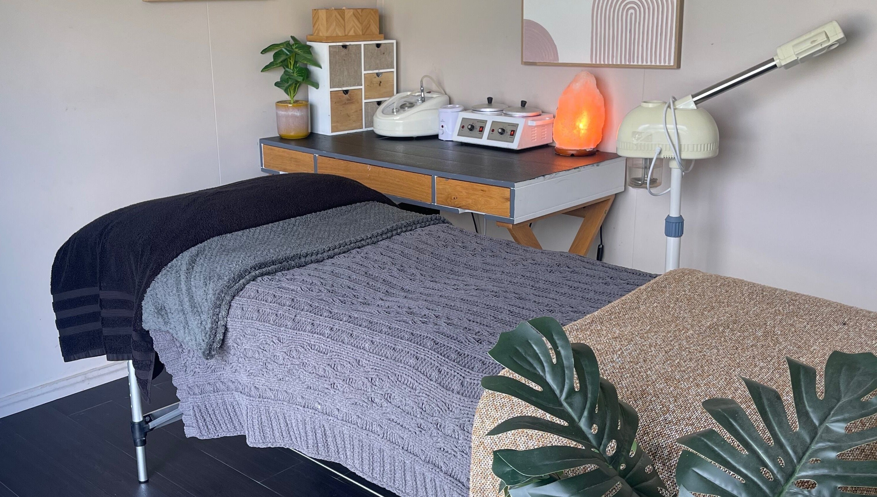 Cozy treatment room at The Littlest Beauty Studio, Auckland, NZ with massage table and soft lighting.