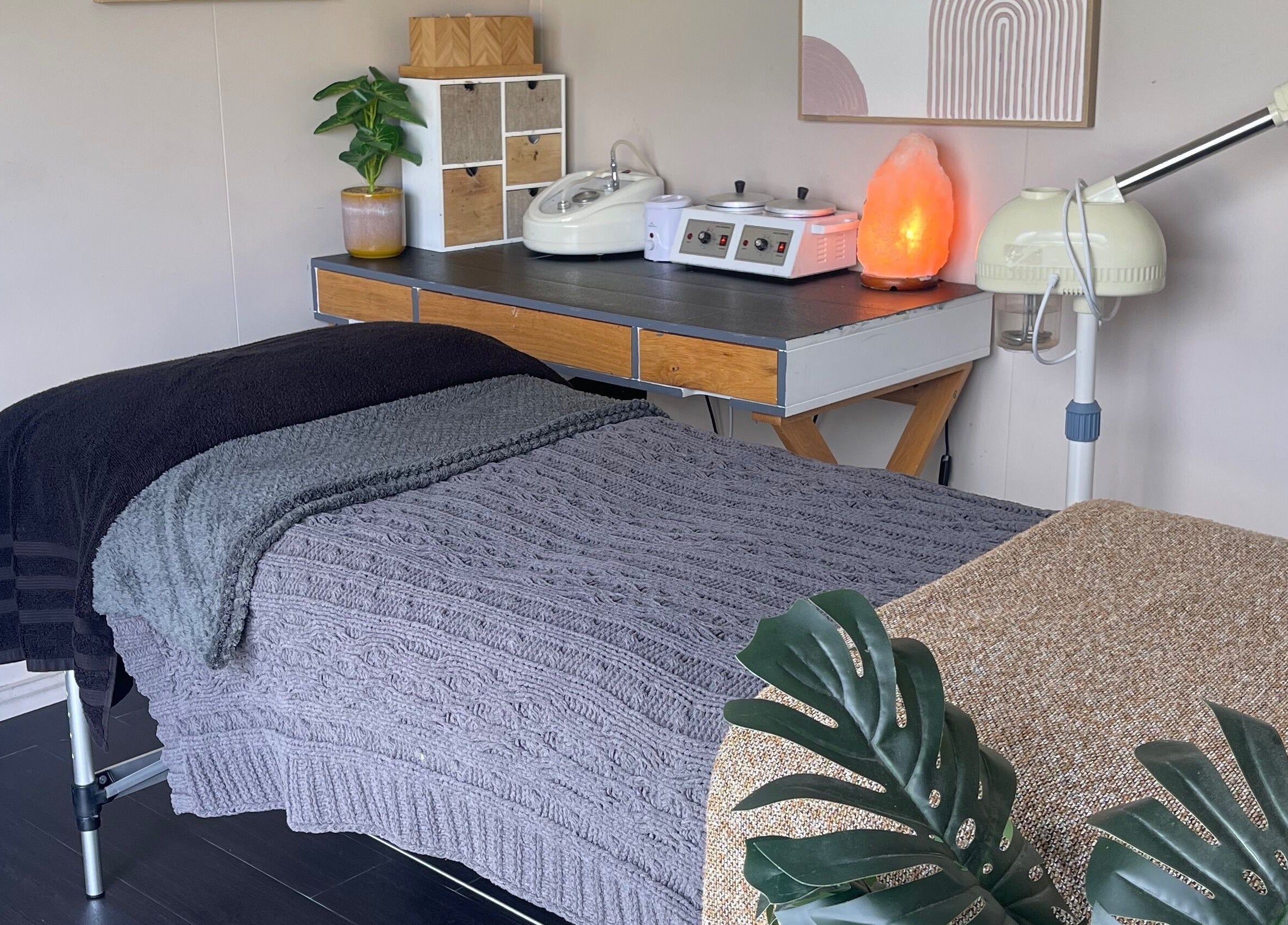 Cozy treatment room at The Littlest Beauty Studio, Auckland, NZ with massage table and soft lighting.