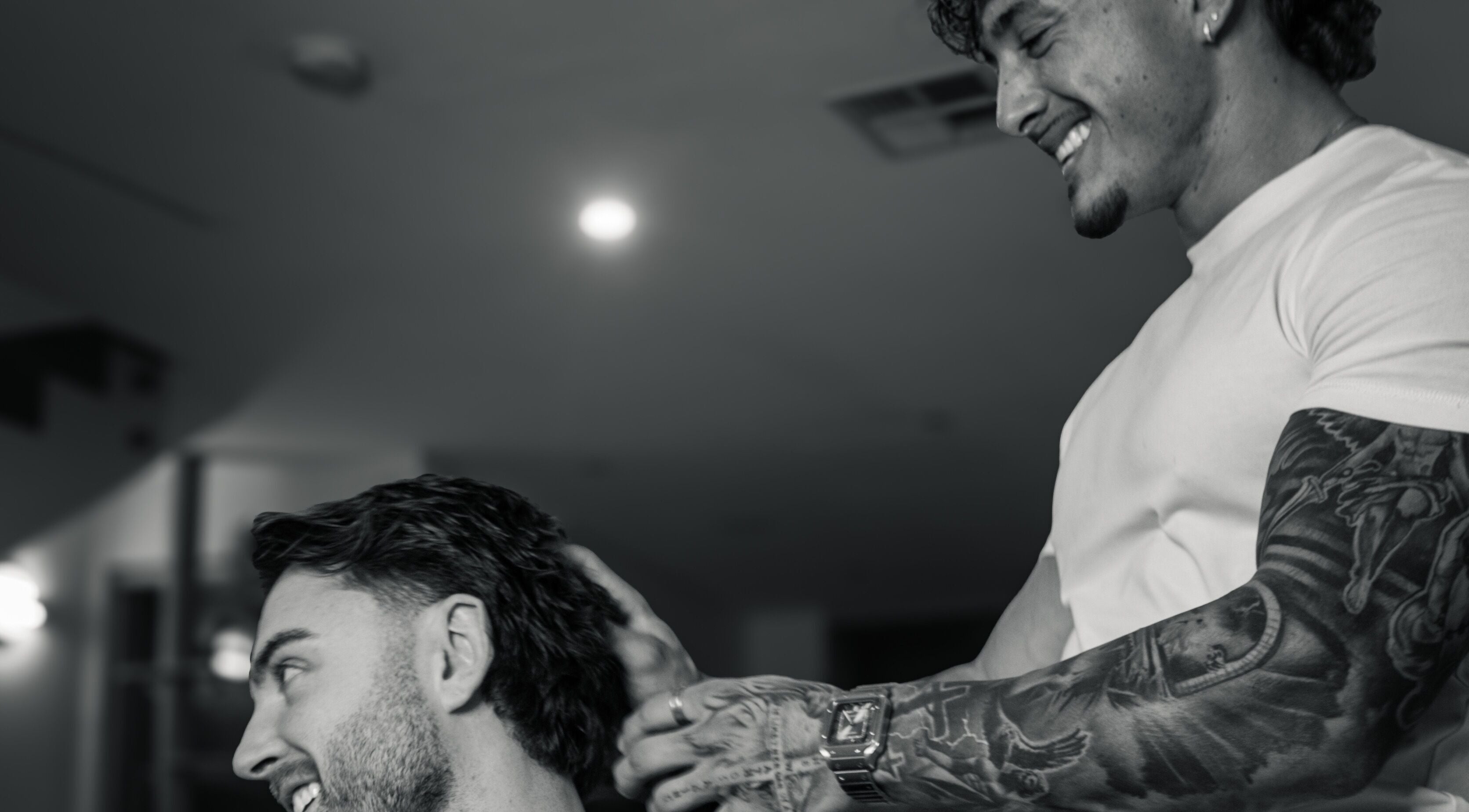 Barber at Studio 61 Barbershop, Long Jetty, NSW giving a stylish haircut with a smile.