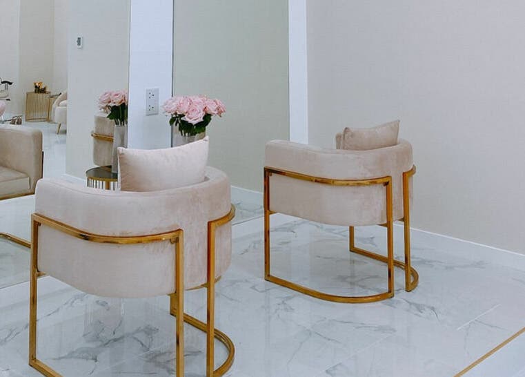 Décor chic de Joséphine Nails Dubai à Dubai, AE avec fauteuils luxueux et fleurs roses.