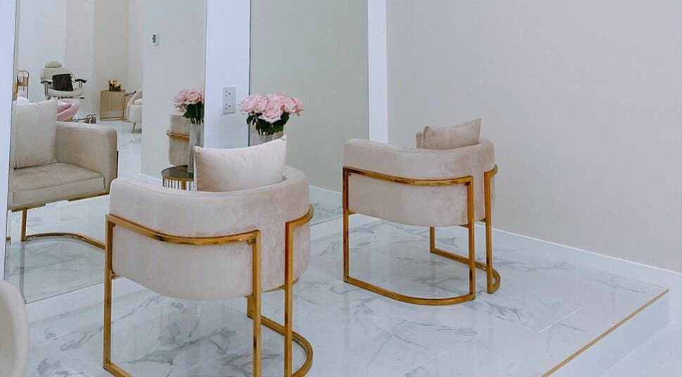 Décor chic de Joséphine Nails Dubai à Dubai, AE avec fauteuils luxueux et fleurs roses.