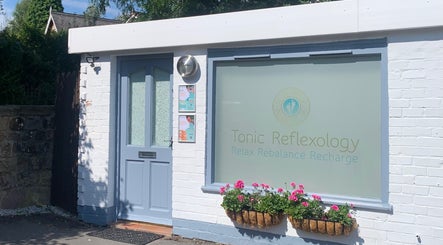 Exterior of Tonic Reflexology, Derby, England, GB, featuring a welcoming entrance and vibrant flower display.