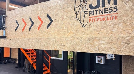Loft-style interior at Indigo Massage at 3M Fitness, Nettlestead, GB with wood-textured walls and bold graphics.