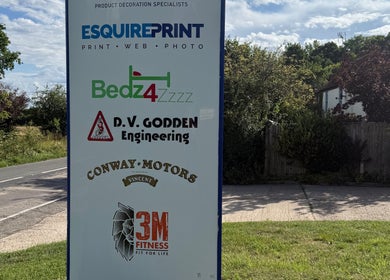Signboard displaying various business logos, including Indigo Massage at 3M Fitness, Nettlestead, GB.