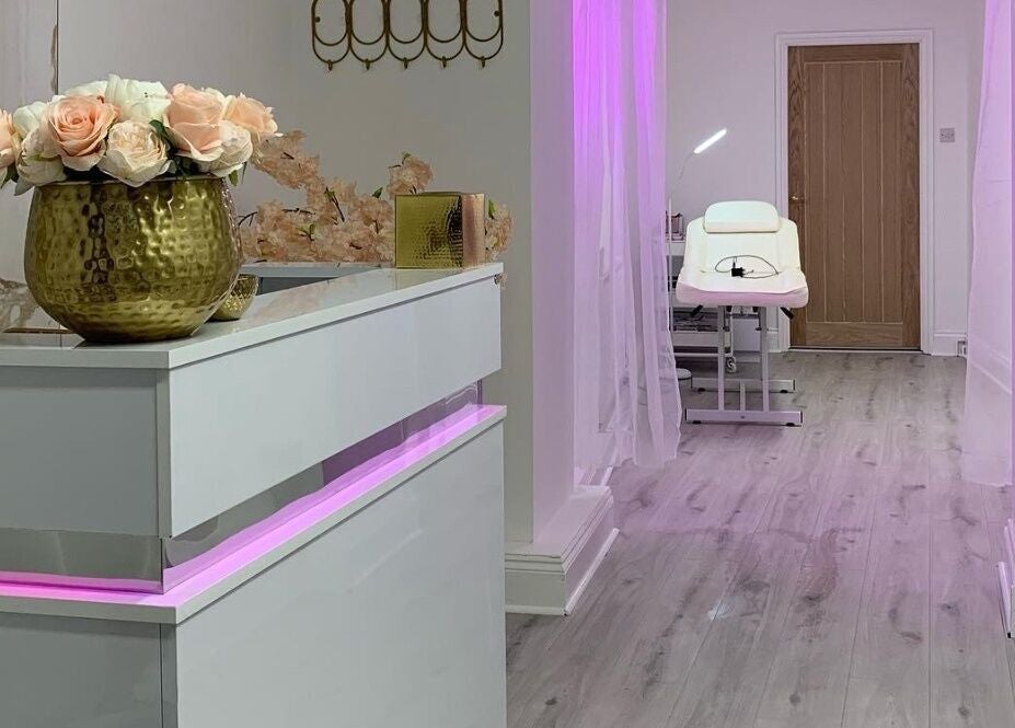 Elegant reception and treatment room at Darlalash, Kettering, England, GB with pink lighting and floral decor.