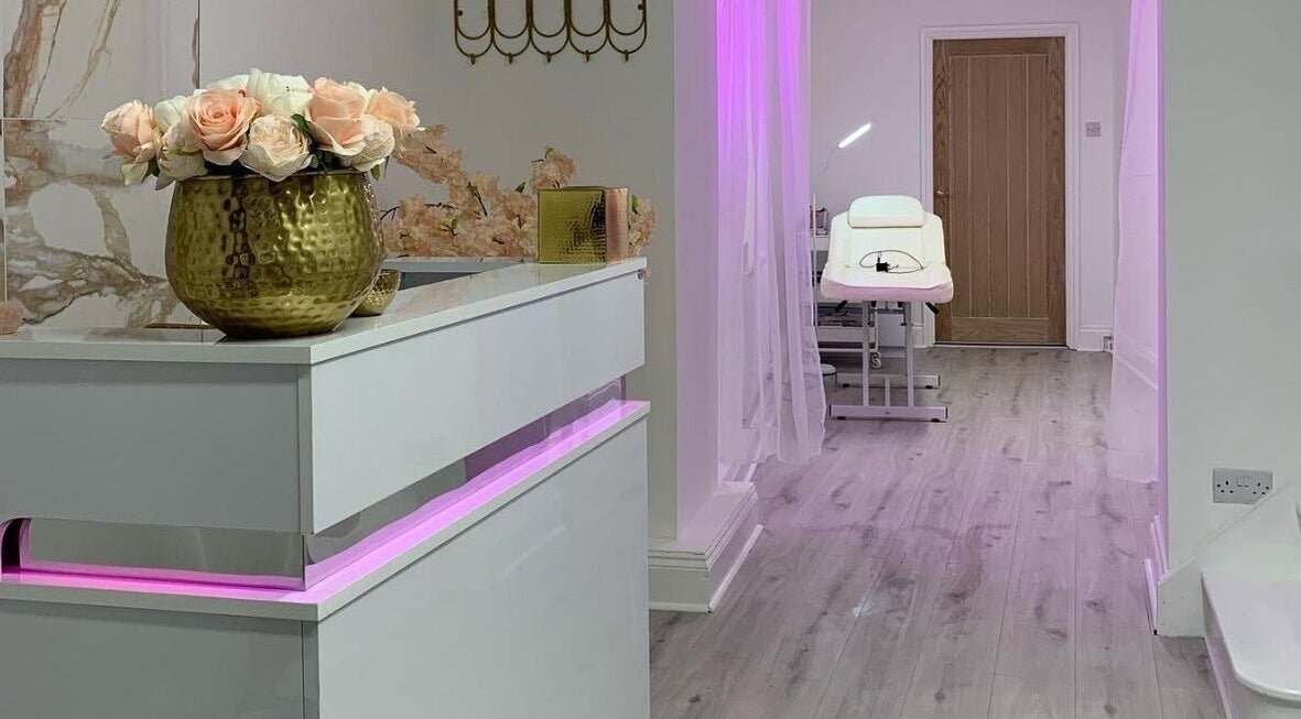 Elegant reception and treatment room at Darlalash, Kettering, England, GB with pink lighting and floral decor.