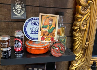 Mo Barbershop in Wien, AT zeigt Retro-Frisierprodukte auf stilvollen Regal.