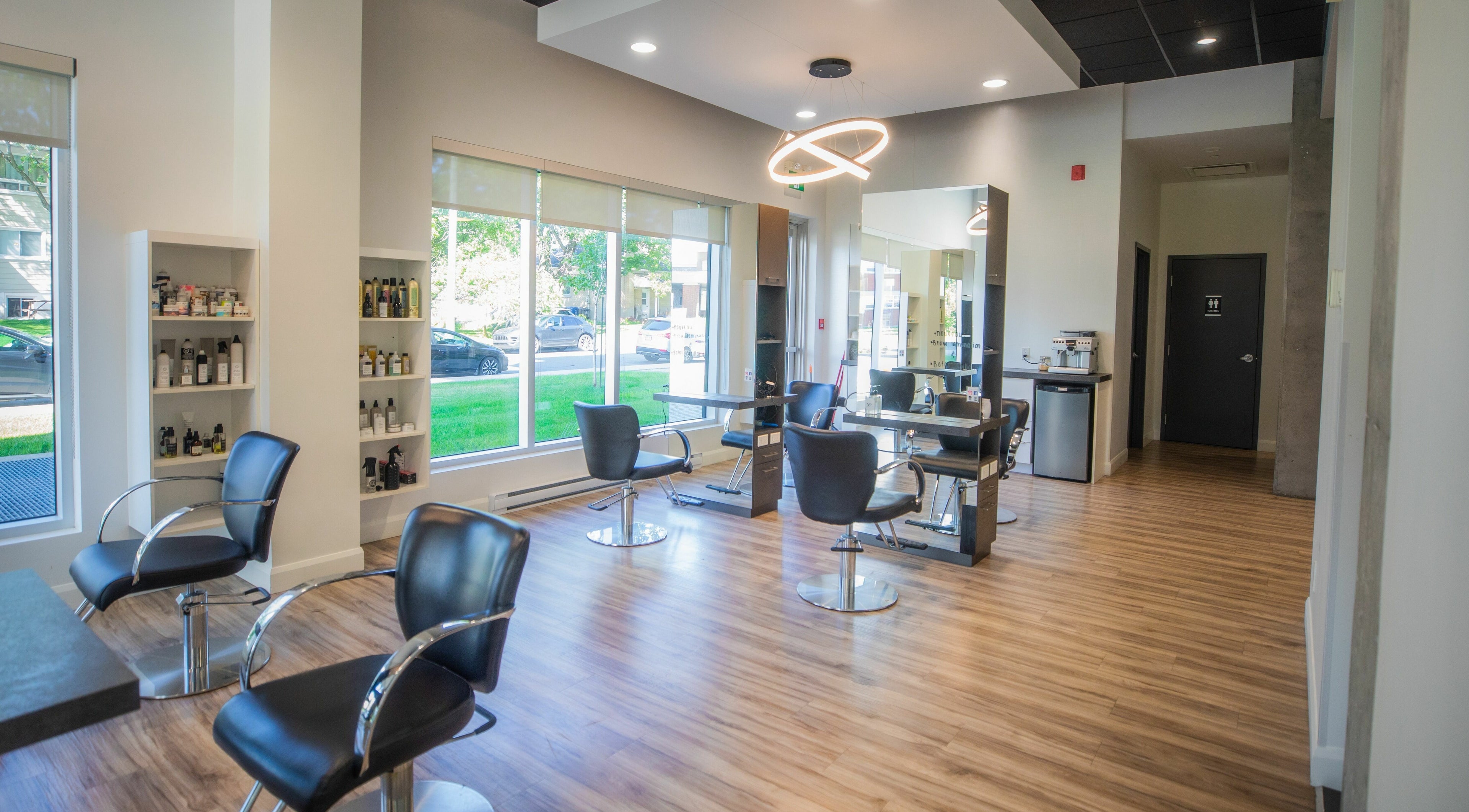 Intérieur moderne de XO Institut, Québec, Québec, CA, avec fauteuils élégants et grande fenêtre.