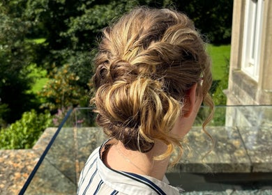 Elegant braided hairstyle at Poison Ivy Hair By Brooke, Windermere, England, GB, with lush greenery in the background.
