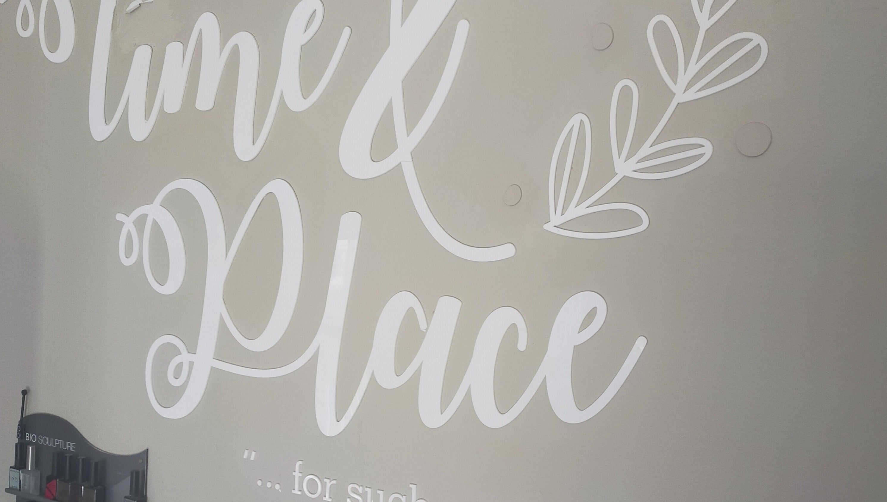 Decorative wall art at Time and Place Beauty in Roodepoort, Gauteng, ZA, featuring a graceful script design.