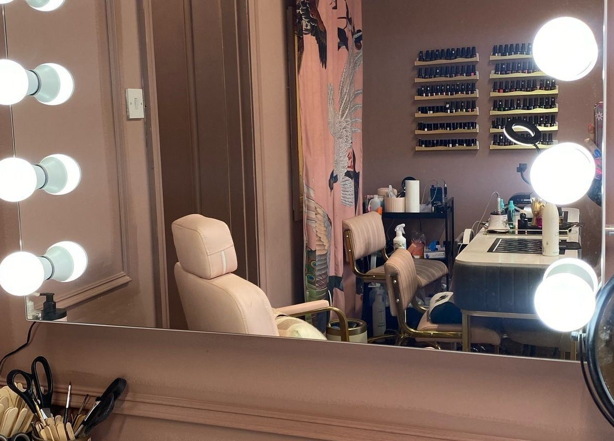 Chic makeup station at Vamp Beauty Bar, Westport, County Mayo, IE, featuring illuminated mirror and comfy chairs.