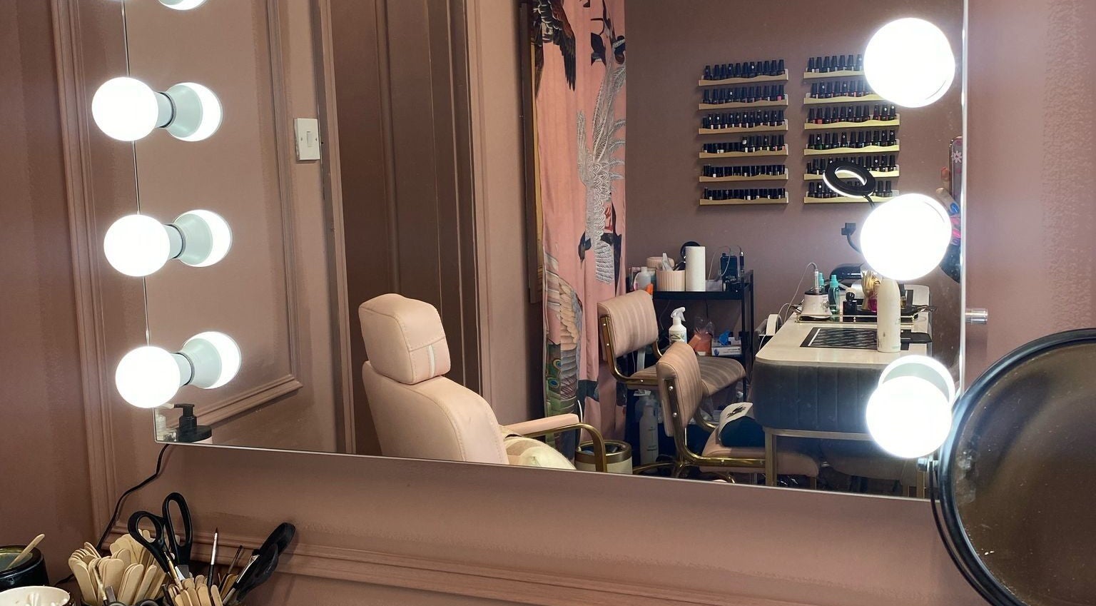 Chic makeup station at Vamp Beauty Bar, Westport, County Mayo, IE, featuring illuminated mirror and comfy chairs.