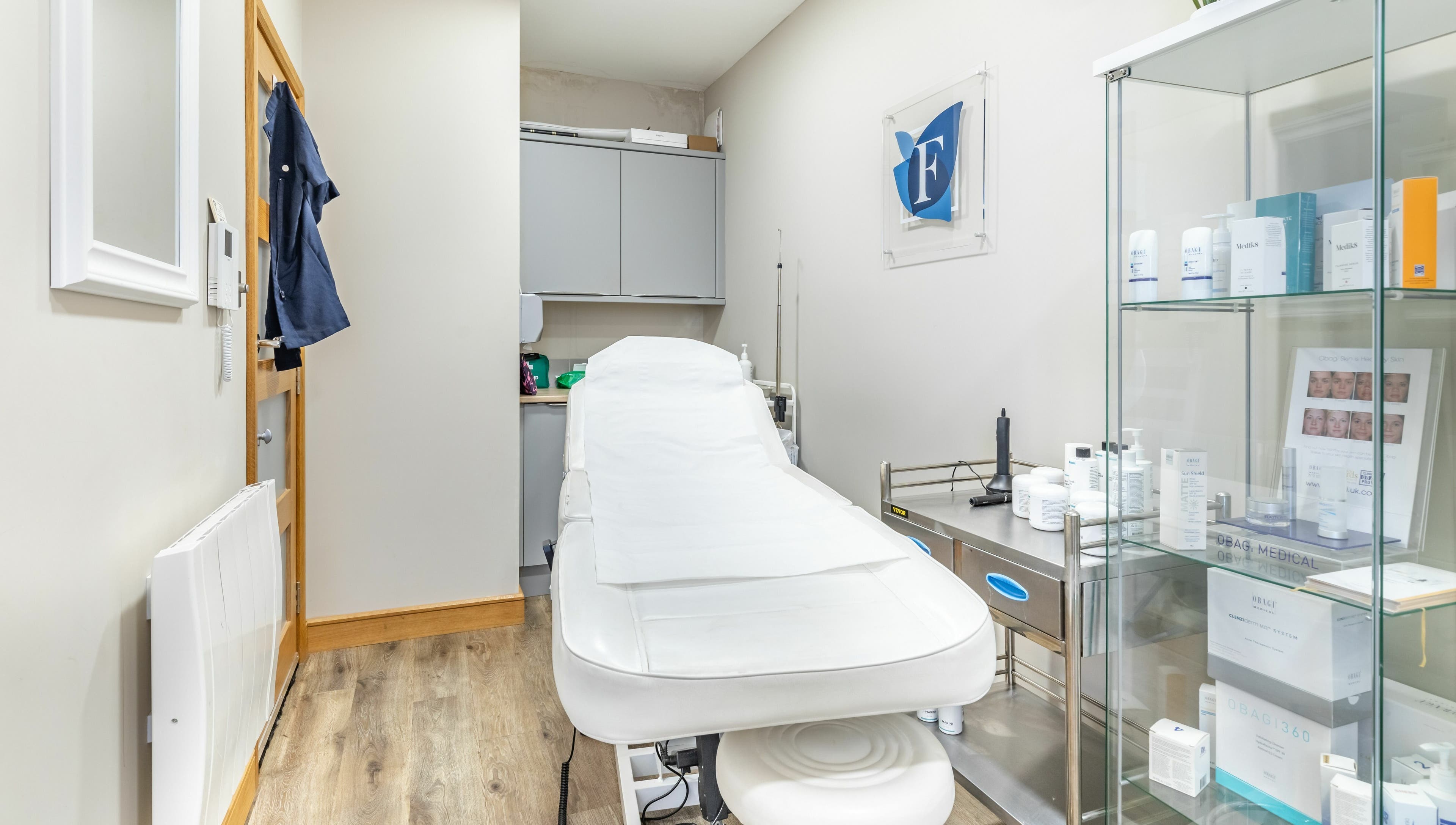 Treatment room at Frontalis Clinic in Portishead, England, GB featuring a white treatment bed and skincare products.