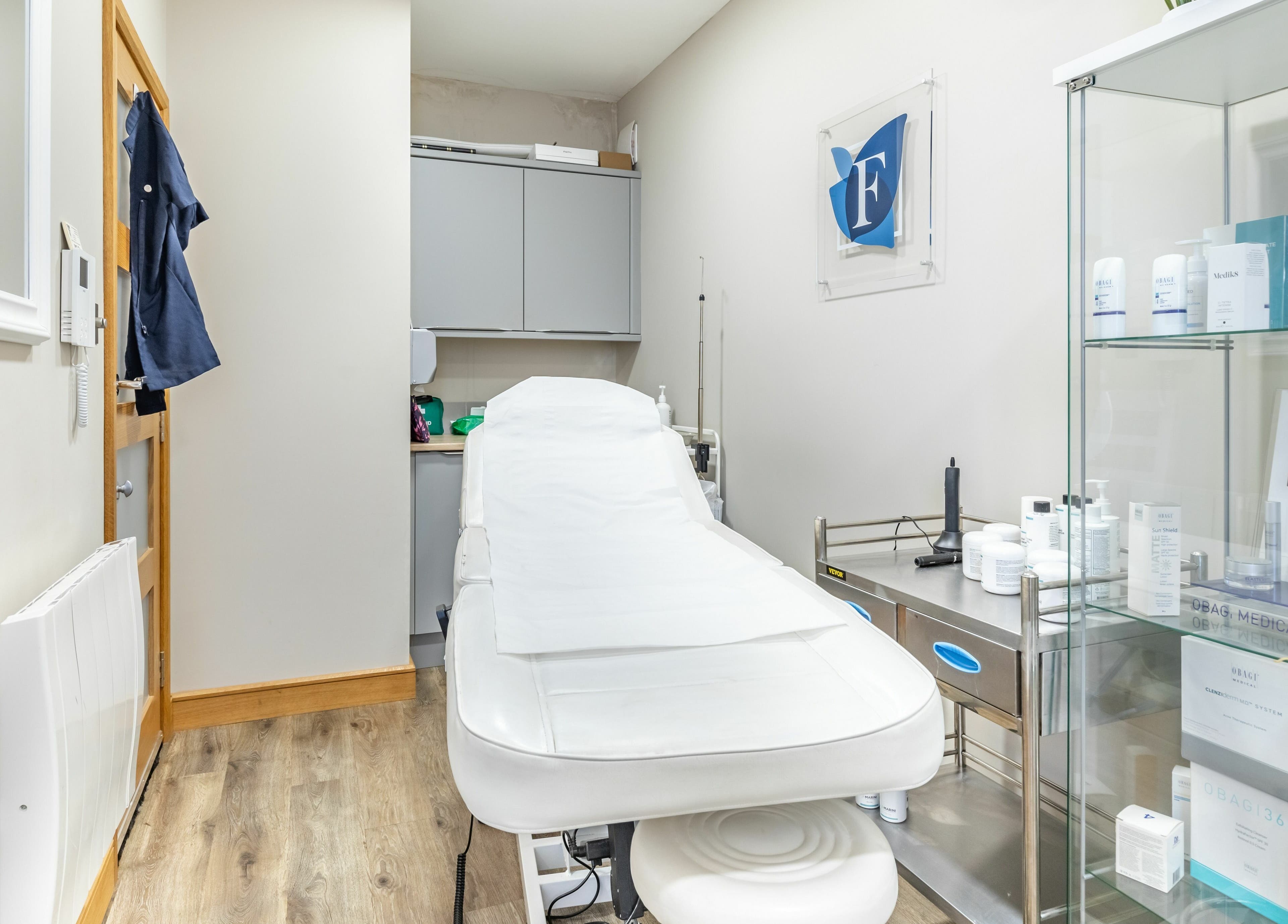 Treatment room at Frontalis Clinic in Portishead, England, GB featuring a white treatment bed and skincare products.