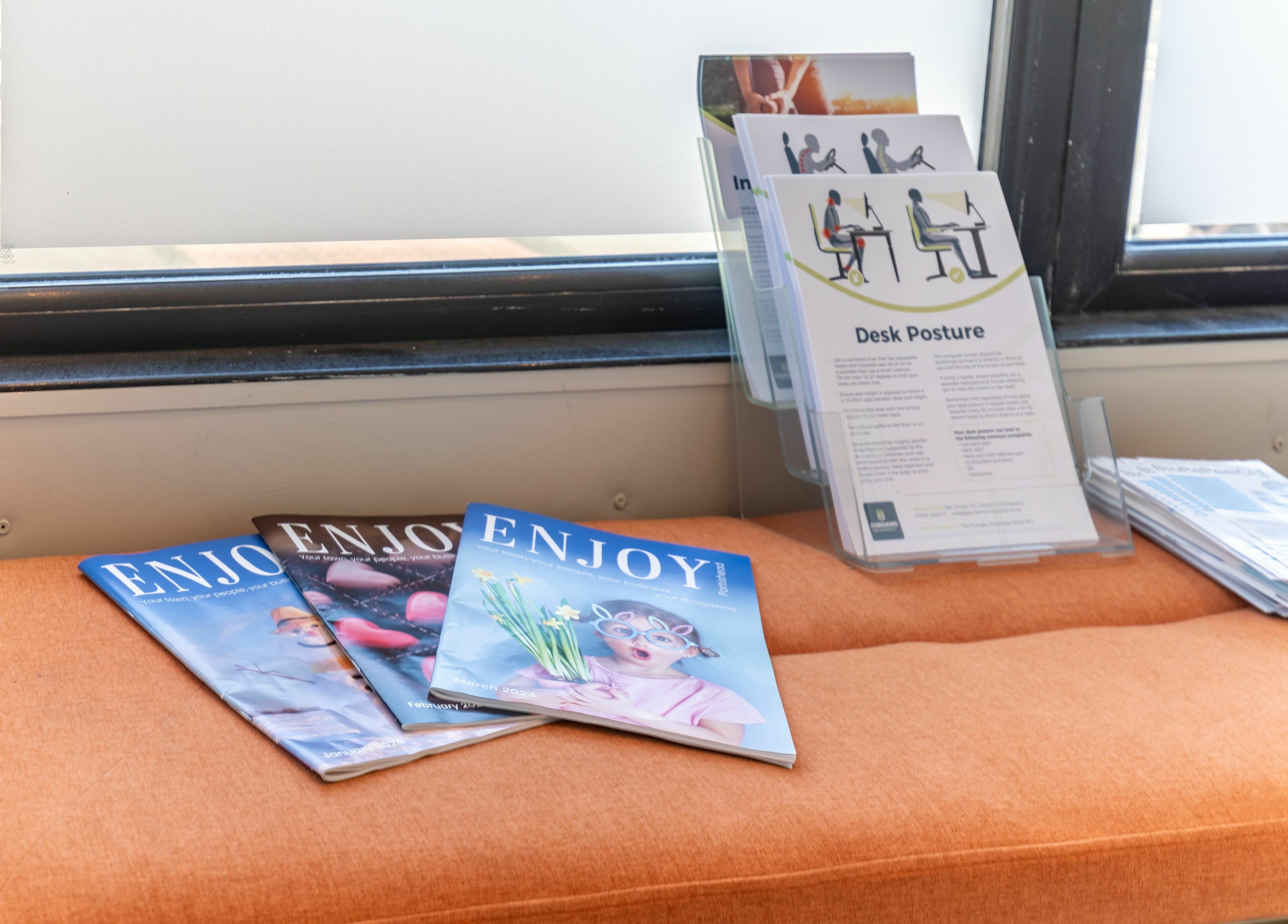 Magazines and brochures on an orange bench at Frontalis Clinic, Portishead, England, GB.