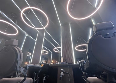 Interior modern la History Barbershop Stefan Cel Mare din București, București, RO, cu scaune și luminițe circulare.