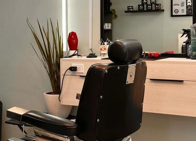 Moderno interior en Barbería Boss Perla, Tijuana, Baja California, MX, destacando silla y decoración estilizada.