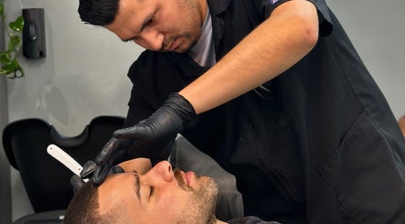 Barbero realizando afeitado preciso en Barbería Boss Perla, Tijuana, Baja California, MX.