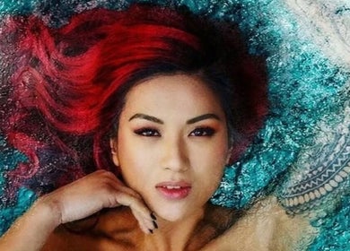 Vibrant red-haired woman with tattoos at Allure Hair and Co, Coburg, Victoria, AU, showcasing beauty services.