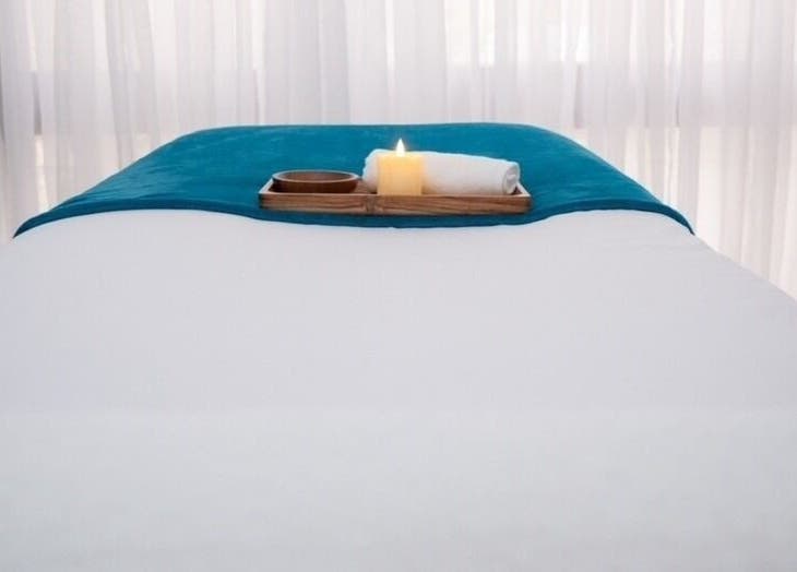 Calm massage table setup at Aphros Beauty, Homewood, Alabama, US with candle and towel.